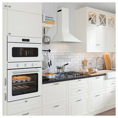 Modern white kitchen with built-in oven, microwave, and gas range. Hilite accessories and wooden utensils are neatly arranged on the countertop.