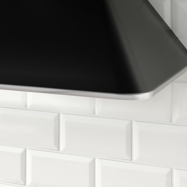 Black modern hood against white tiles.