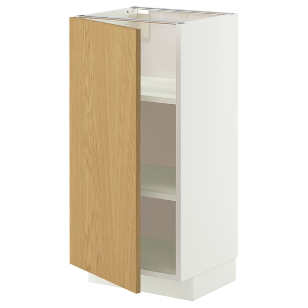 A white METOD kitchen cabinet with a single light oak door open, revealing two shelves.