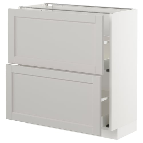 A white METOD kitchen cabinet with bevelled edges. It a drawer and a door, both framed in solid birch with birch veneer panels.
