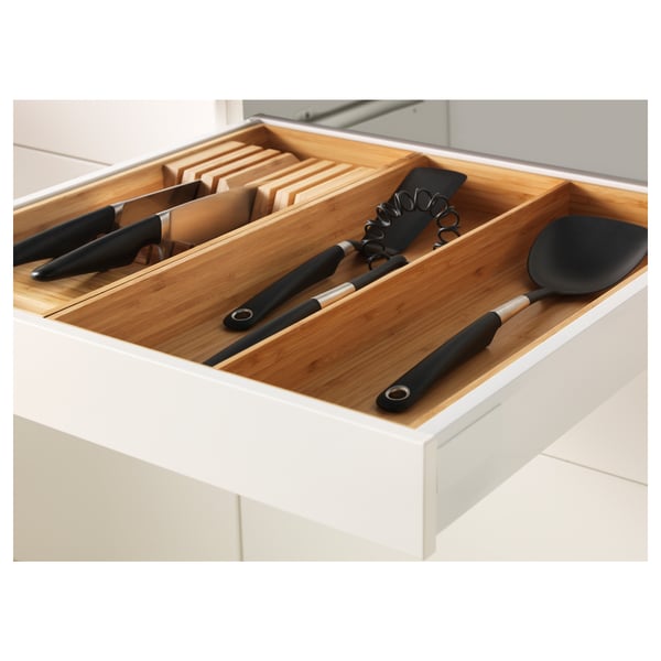 Wooden kitchen drawer organiser with knives and utensils.