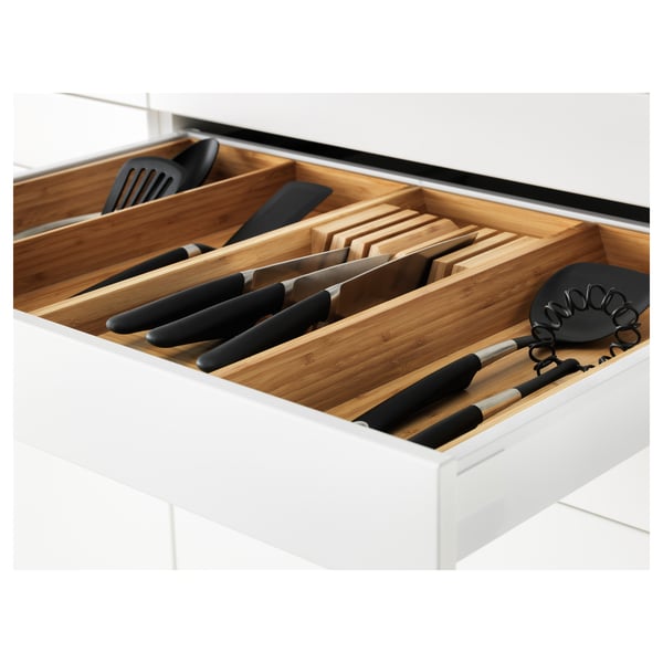 White kitchen drawer organiser with bamboo dividers storing knives and utensils.