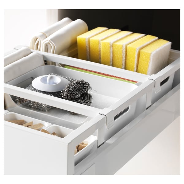 Organised kitchen drawer with sponges, brushes, and clothespins in compartments.