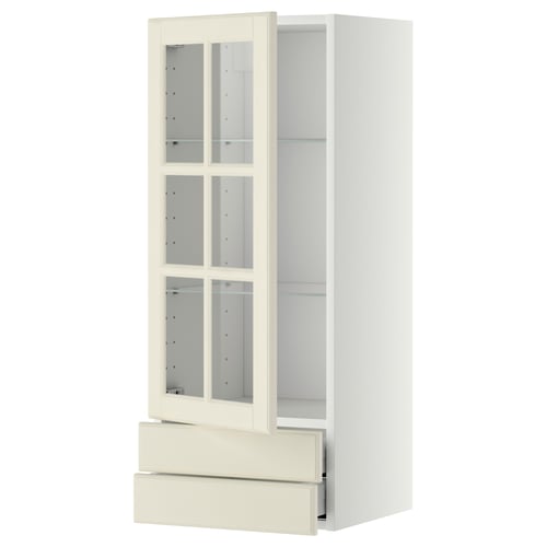 METOD kitchen unit: white cabinet with glass doors, adjustable shelves, and a drawer. Traditional design with bevelled edges.