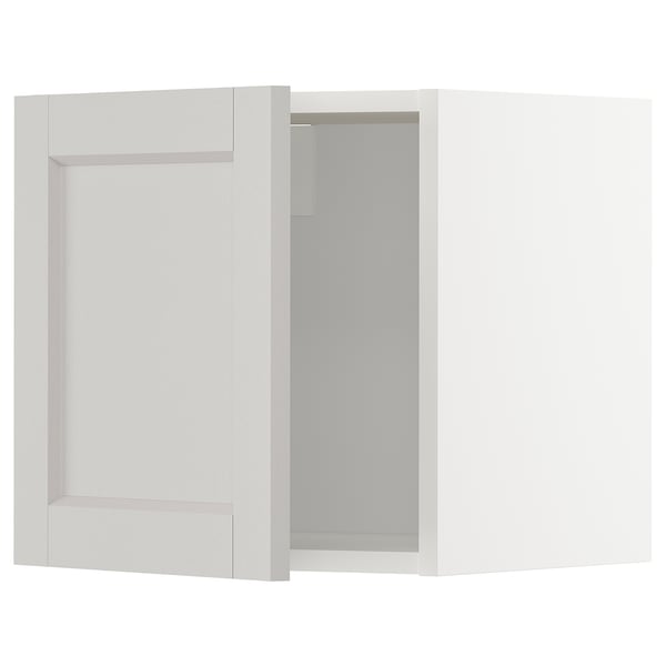 White METOD kitchen cabinet with beige frame and glass door.