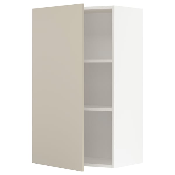 A beige METOD kitchen cabinet with a white interior and two shelves. The cabinet door is closed, and the design is sleek and modern.
