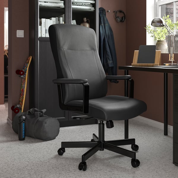 Modern home office with MILLBERGET black swivel chair, desk, books, and decor.