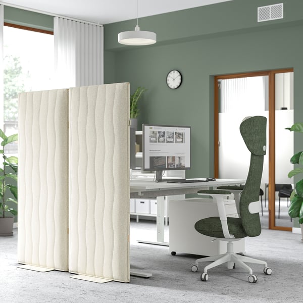 Office workspace with MITTZON acoustic screen, green chair, white desk, computer, clock, curtains, and plants.
