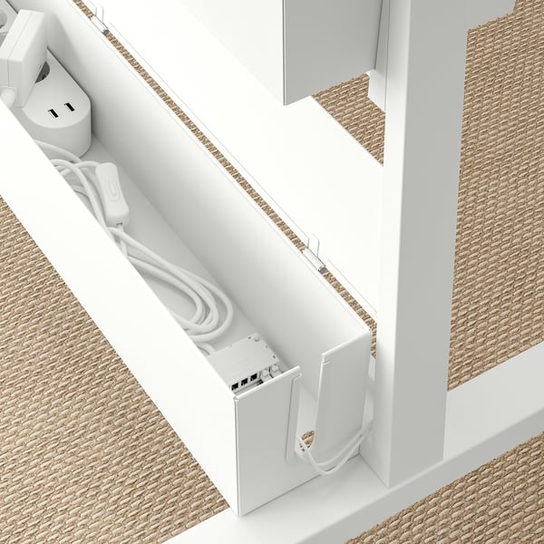 White cable box with cords and plugs, designed for organising and hiding cables. Part of the MITTZON system.
