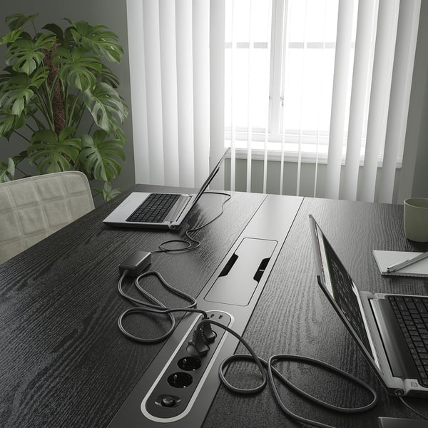 Conference room with laptops and plant.