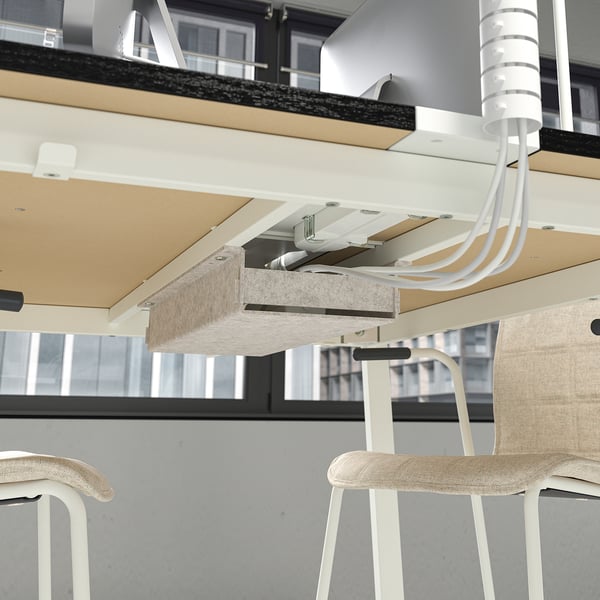 High conference table with footrest and cable management for meetings.