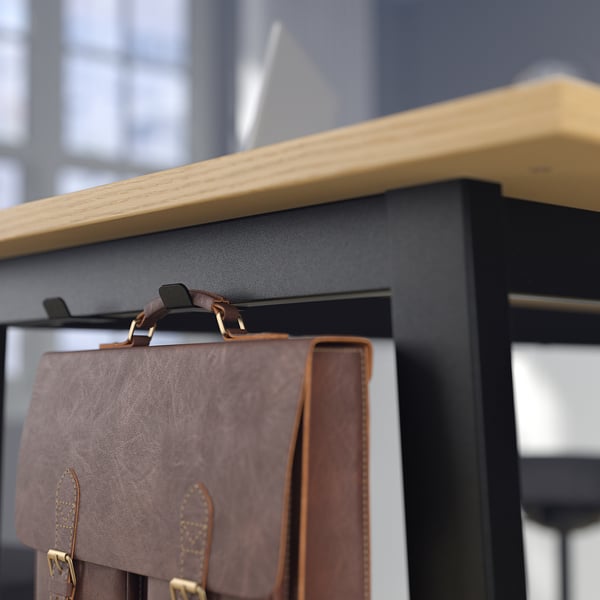 Brown leather bag hangs on black shelf with wooden edge.