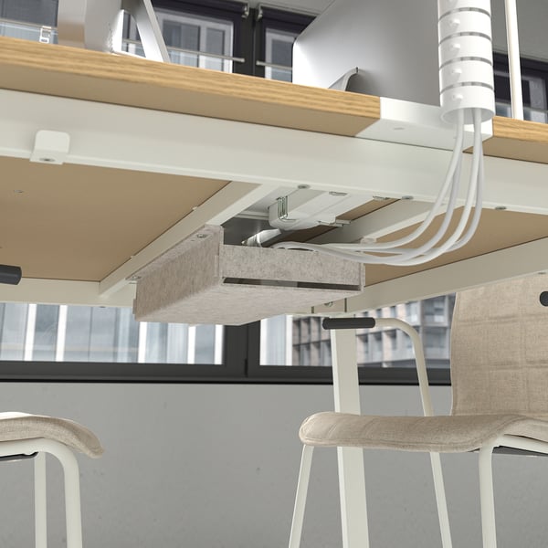 Conference table with cable management. Hooks for headphones seen, perfect for meetings.