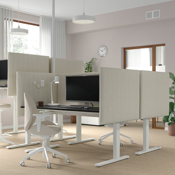 MITTZON sit-stand desks with light beige screens, dual motors, in modern office with plants, lights, and clock.