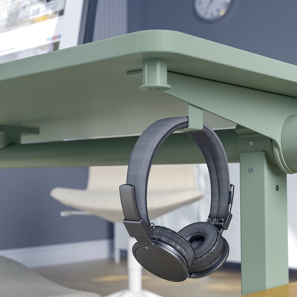 Headphones hang on desk hook.