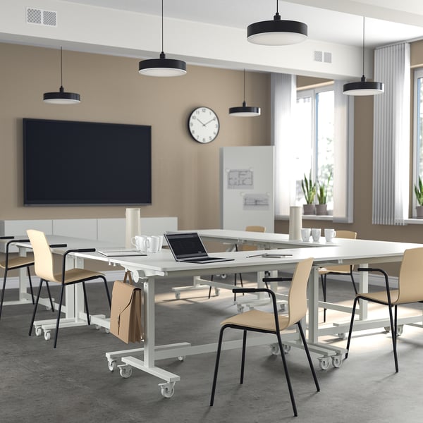 Modern office with MITTZON tables, chairs, and lights. Movable tables, stackable chairs. Well-lit, flexible meeting space.