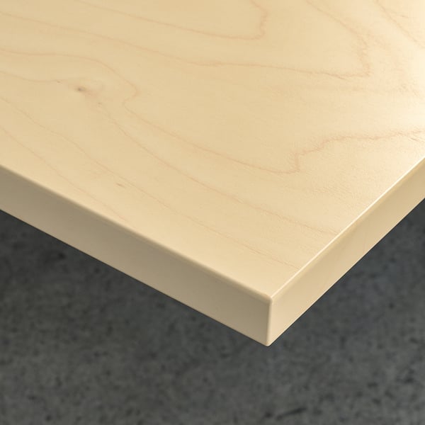 A pristine light-colored wooden table corner, clean and smooth, showcasing quality and durability.