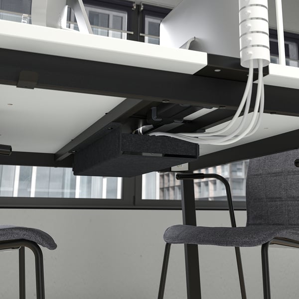 Underneath table with power cables routing system, ready for conference setup.