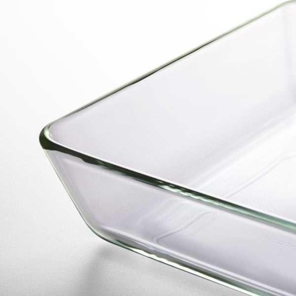 Clear glass baking dish with gently curved edges, resting on a white surface.