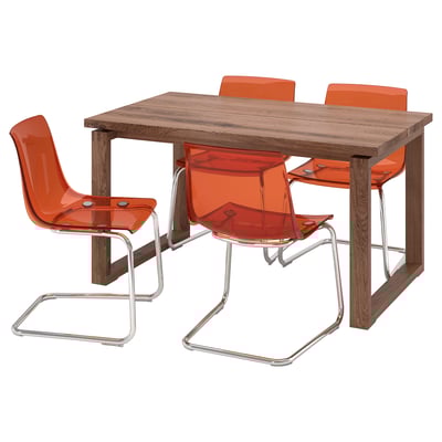 Modern dining set with brown wooden table, four orange plastic chairs, chrome metal legs.