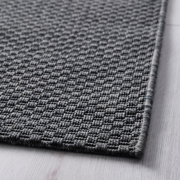 Close-up of MORUM rugs woven texture, showcasing its durable grey material.