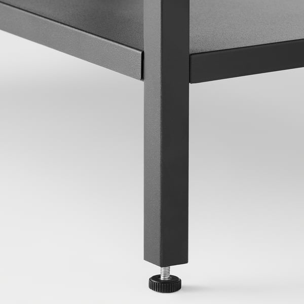 Close-up of modern table leg with adjustable footer for stability.