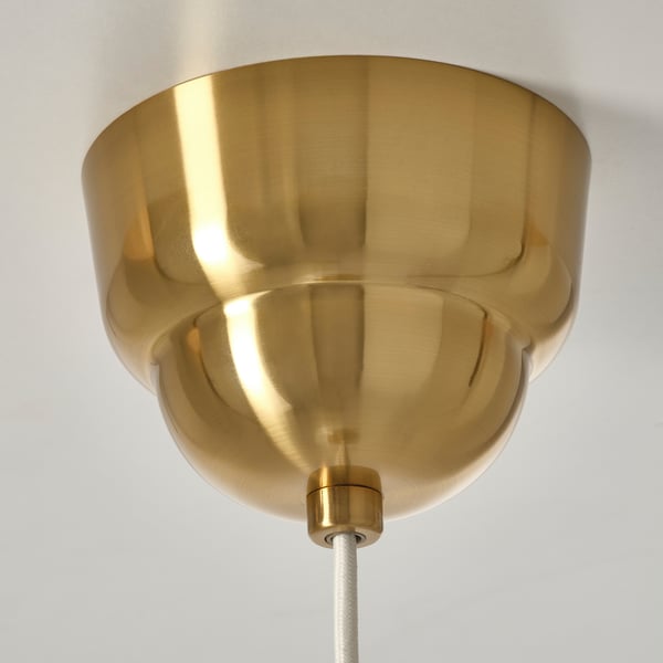 Golden pendant lamp shade, polished with intricate design, suspended by cord, reflecting gleaming craftsmanship.