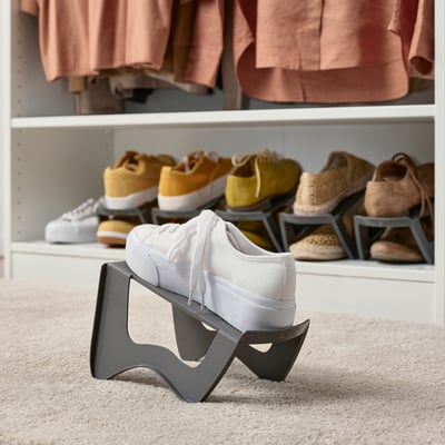Shoe storage rack holding white trainer, showing vertical organisation for space efficiency.