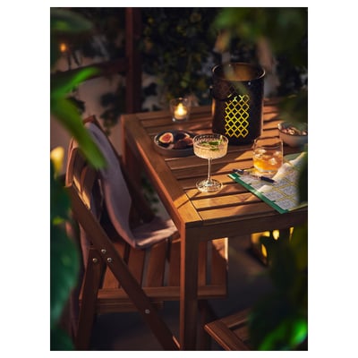 Nammaro set: outdoor table & chairs with snacks, candles, & blanket for cozy evenings.