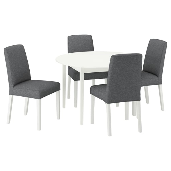 Modern round white dining table with four grey upholstered chairs.