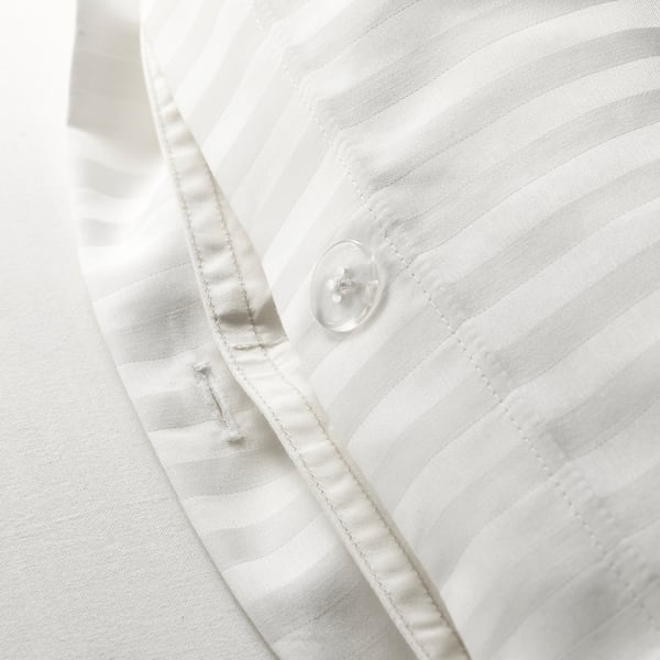 Close-up of a smoothly textured, white duvet cover made of sateen fabric, showcasing delicate stripes and precise stitching.
