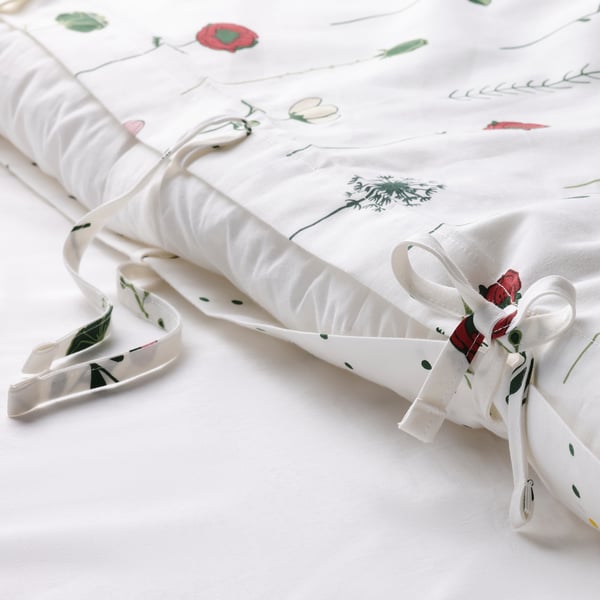 Roll-up duvet cover with ribbon ties, featuring reversible floral or dotted pattern, made from cotton and lyocell for comfort and breathability.