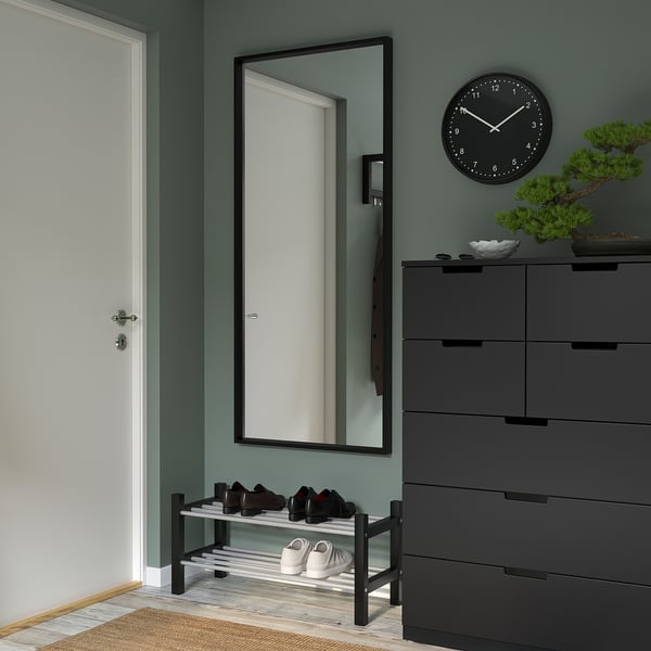 Modern entrance with large NISSEDAL mirror, shoe rack, dresser, clock, plant.