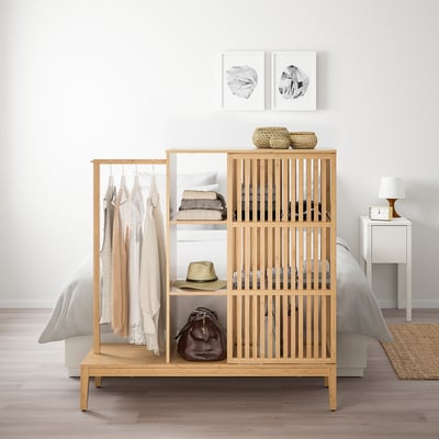 Natural wood NORDKISA wardrobe beside bed, shelves, hanging rod, functional & stylish.