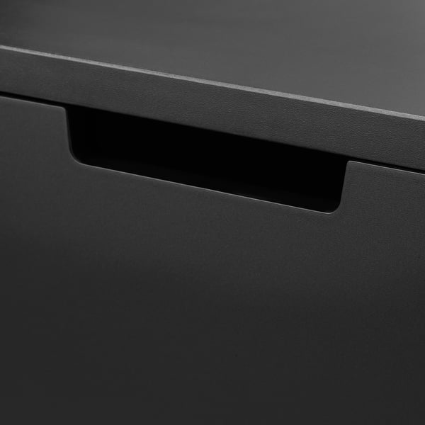 Close-up of smooth, black drawer front with sleek handle. Modern, minimalist design visible.