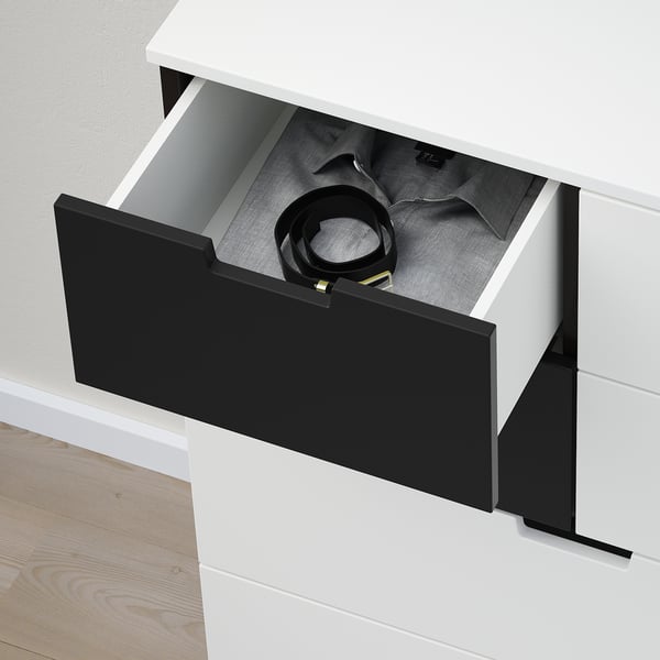 Black cord neatly coiled inside open white drawer of NORDLI chest, highlighting its storage function.