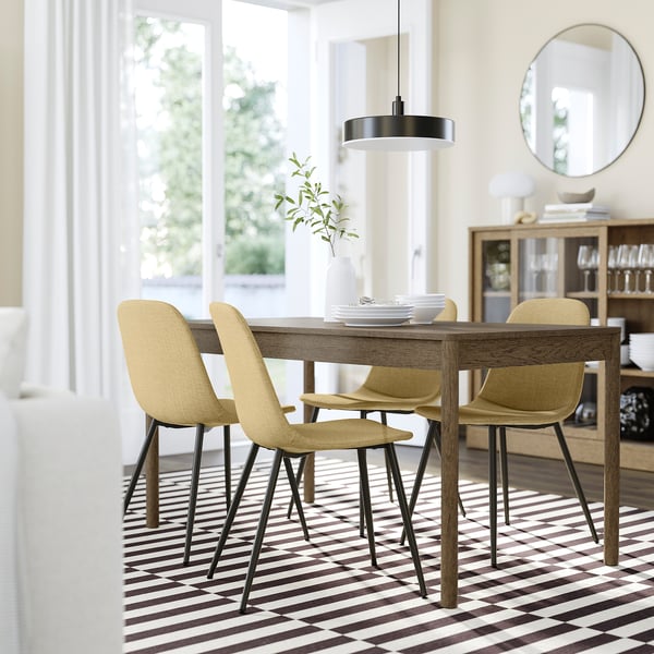 Modern dining set with NORDMANSSKÄR light yellow chairs. Rectangular wood table, striped mat, hanging lamp, mirror, sideboard. Chairs fit under table.
