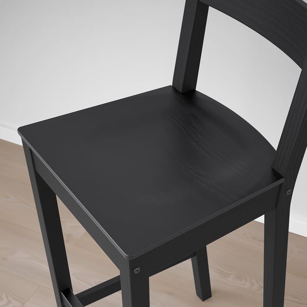 Black wooden chair with a curved backrest and a footrest, designed for comfort and durability.