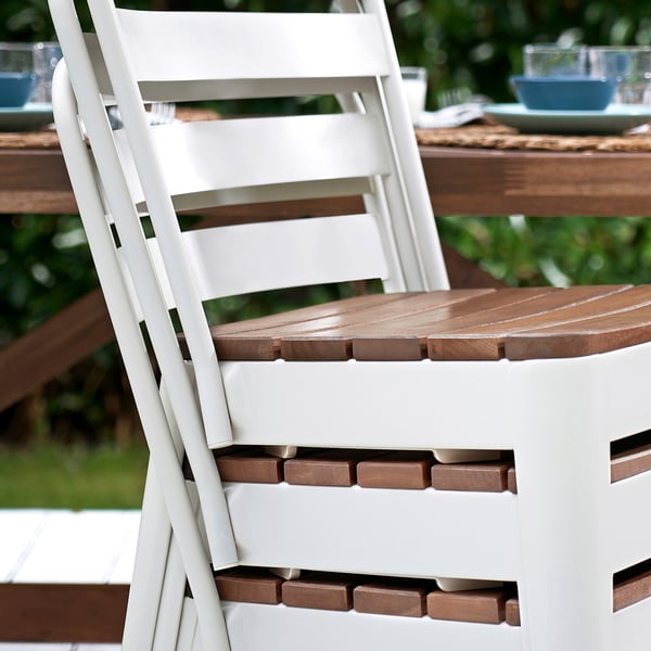 White outdoor chair with wooden seat, part of NORRMANSÖ set, sturdy and stackable.