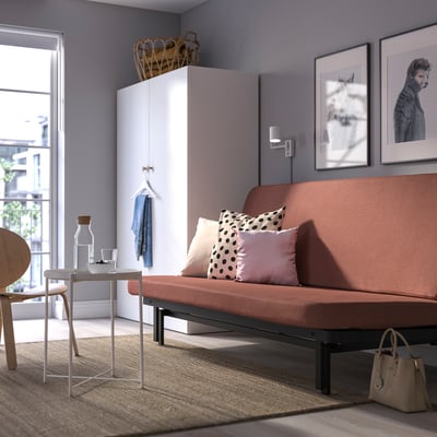 Modern living room with large terracotta sofa, white cabinet, and large window.