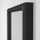 Black-framed mirror on white wall; shows quality and design detail.
