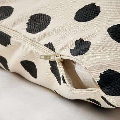 Zip closure on spotted cushion cover, showing easy removal feature.