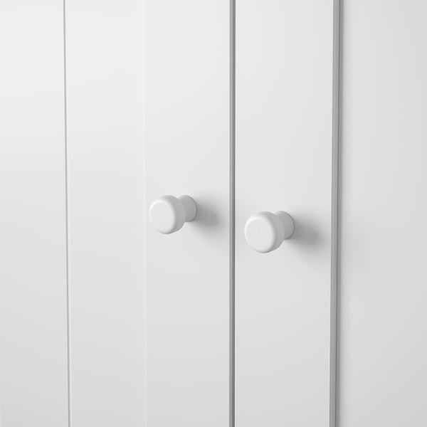 Two sleek white cabinet doors with round, brushed metal knobs, one on each door, positioned near the centre.