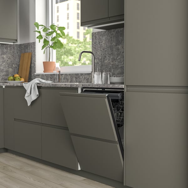 Modern kitchen with integrated built-in grey dishwasher, sleek countertop, and windowsill plant.