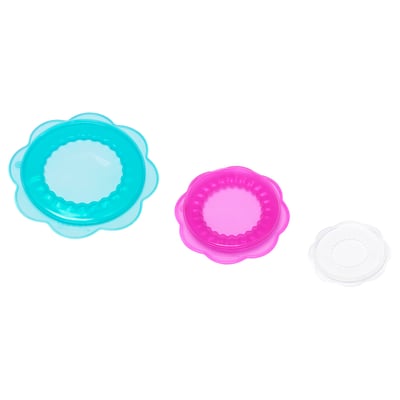Three coloured silicone food covers, shaped like flowers, in blue, pink, and clear colours, designed to fit various containers and keep food fresh.