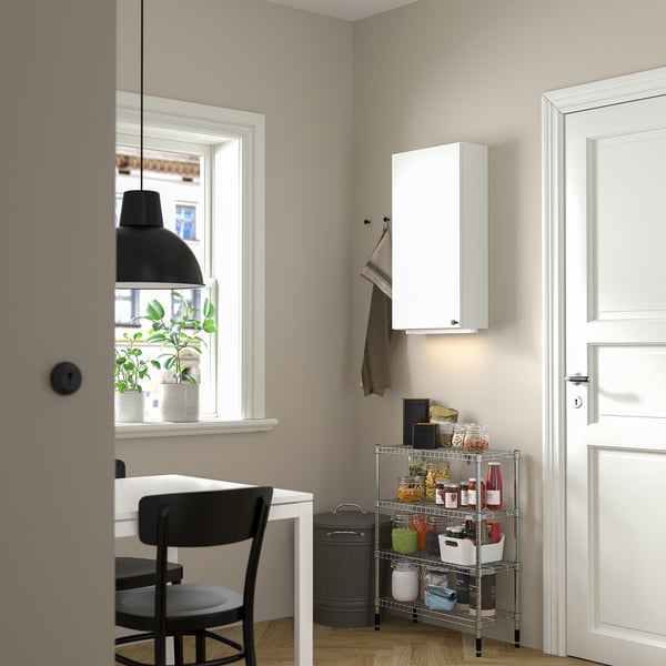 Kitchen corner with OMAR storage, chair, desk, and plant.