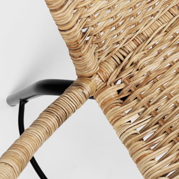 Woven rattan chair detail, natural colour with black metal frame, expertly crafted.