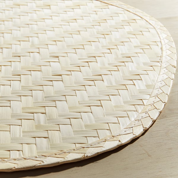 Handwoven ivory place mat with intricate lattice pattern, crafted from palm leaf, showcasing artisanal texture and quality.