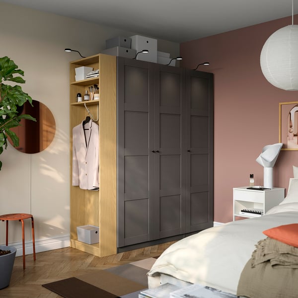 Modern bedroom with dark grey PAX wardrobe, bed, and accessories.