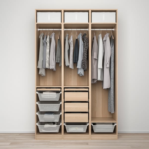 Organised closet with clothes hangers, storage baskets, and drawers in wooden PAX wardrobe.